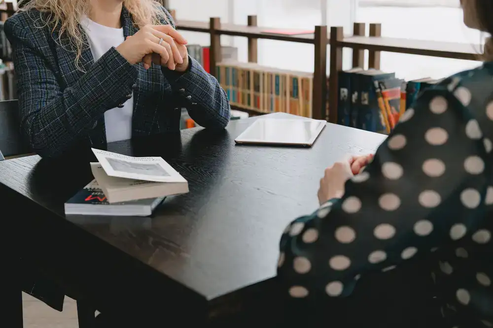 Two people discussing wellness over a wooden table