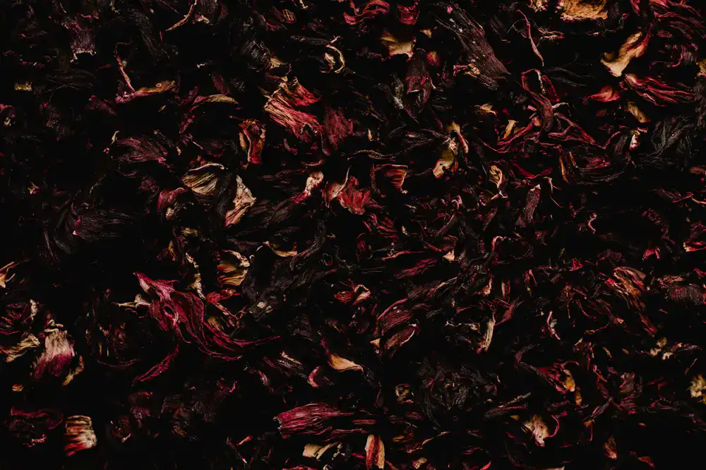 A close-up of a vibrant herbal tea blend on a dark slate surface